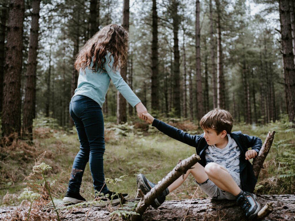 Girl helping boy up from the ground